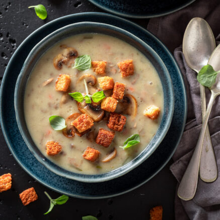 Vegan mushrooms soup with champignons, herbs and cream. Champignons soup made of cream and croutons.